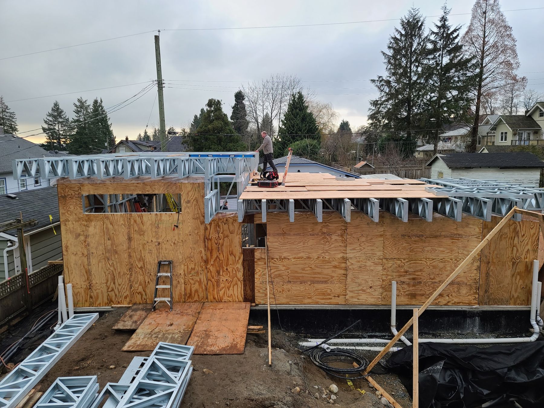 Aerial view of steel roof truss installation on a modular commercial structure